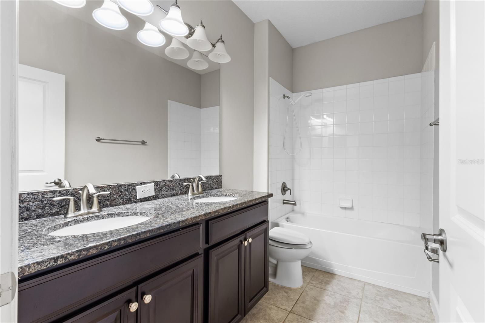 First bathroom with double vanity sinks between the front two bedrooms