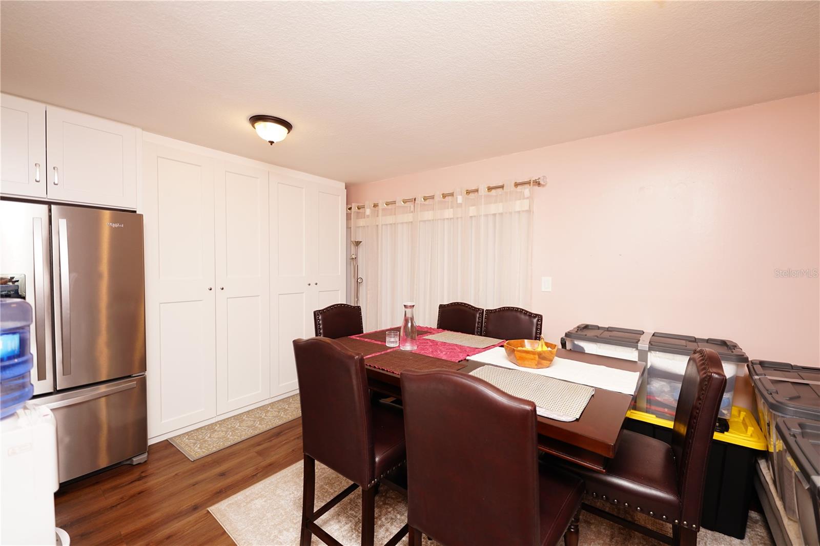 Dining room with the double-door stainless steel fridge visible