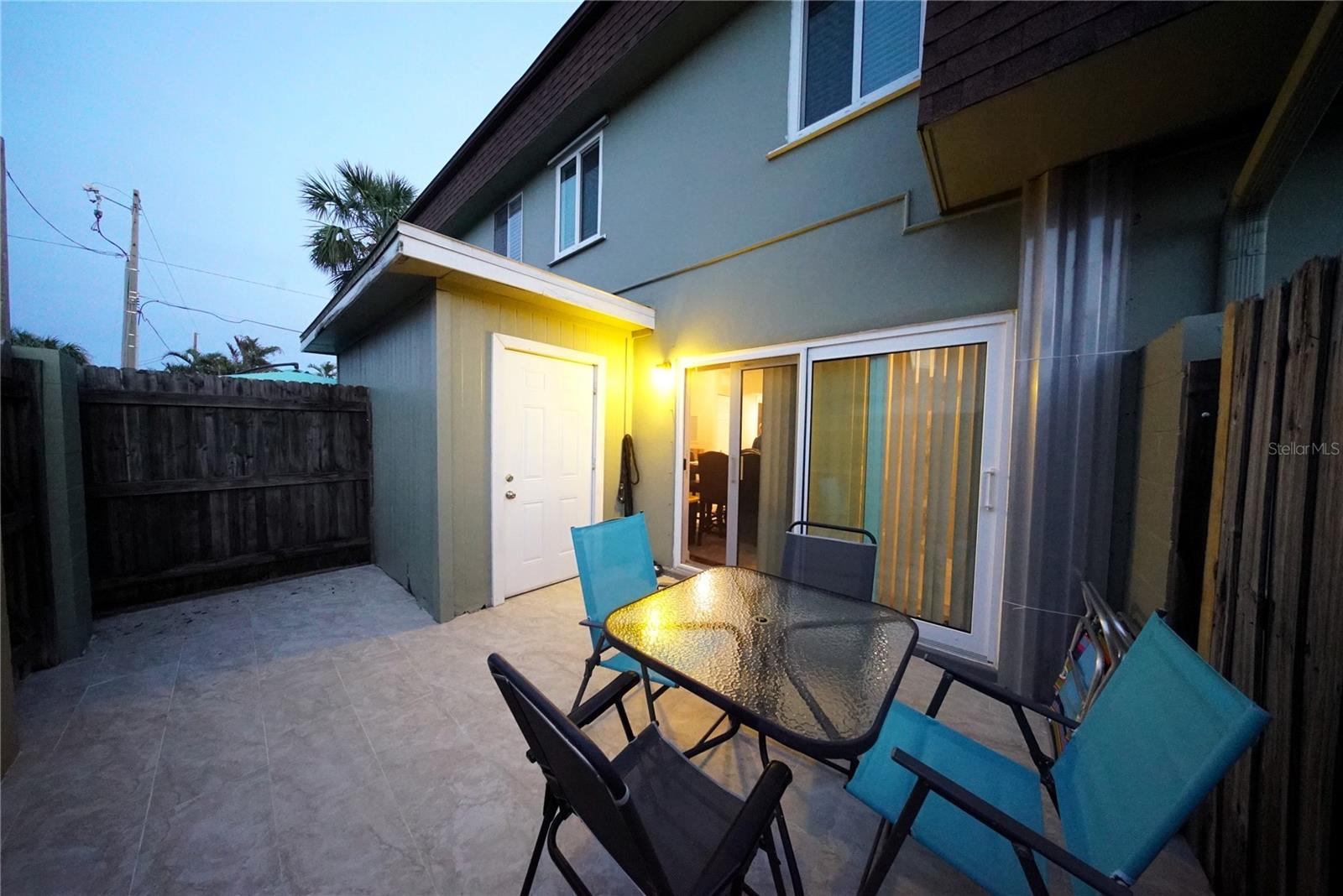 Storage unit visible in fenced-in open patio.