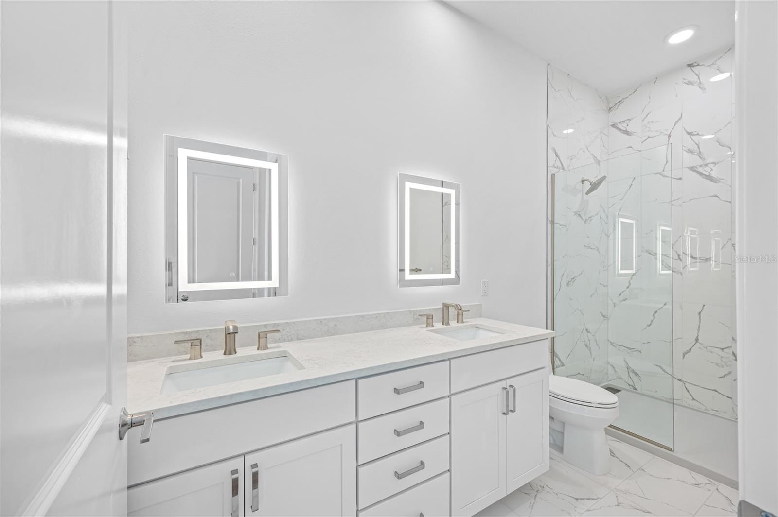 Primary Bath with porcelain tile and double vanities