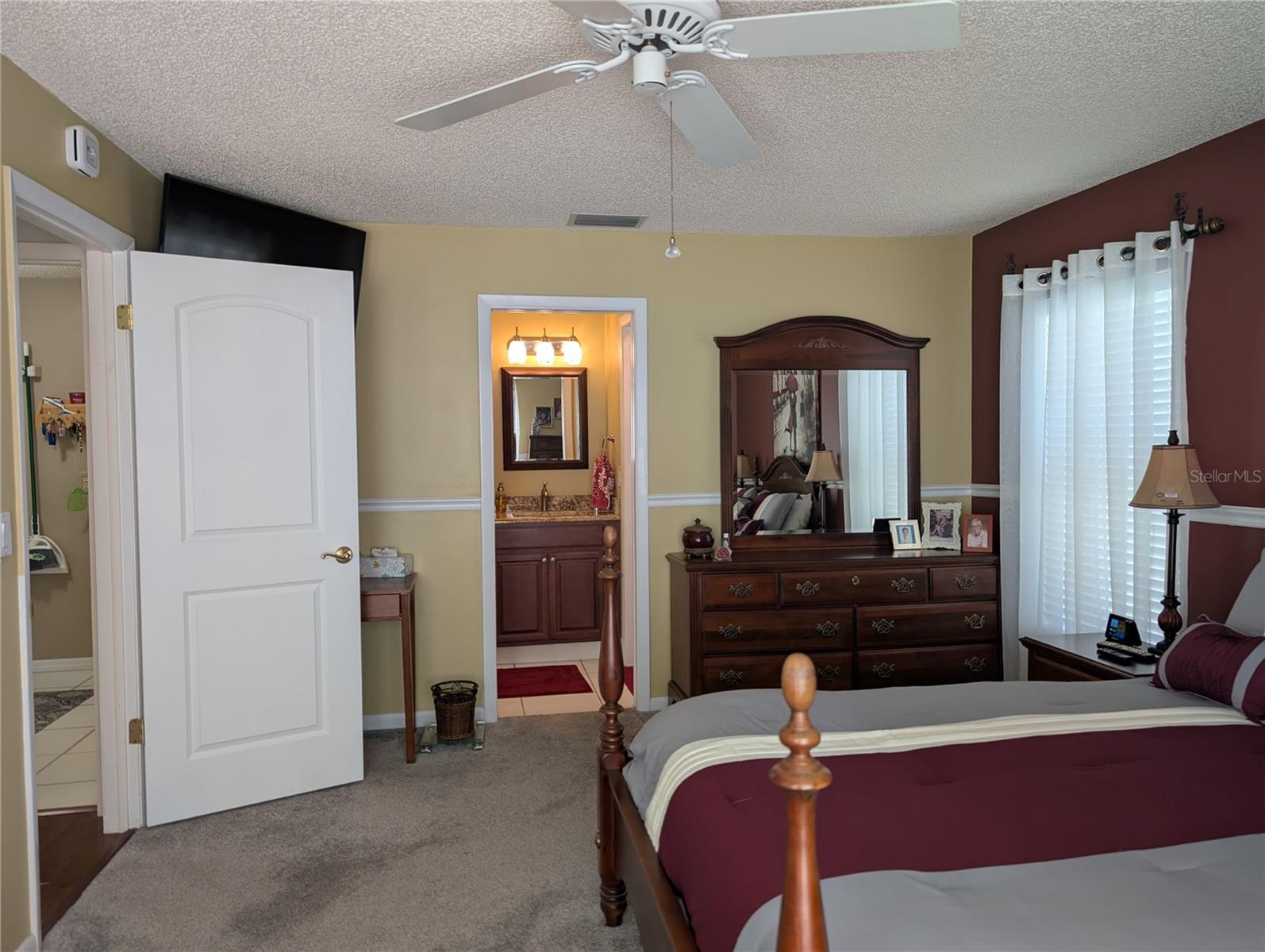 View back to hallway into laundry room and primary bath.  There are 3 special carbon monoxide/smode detectors in the home...one is located above the primary bedroom door.