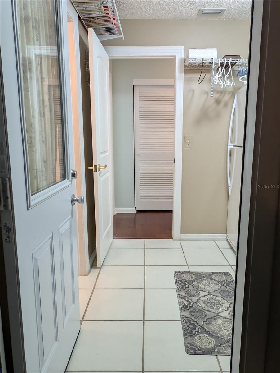 View of laundry from garage entry.  Primary bath is on left and hall closet is straight ahead.