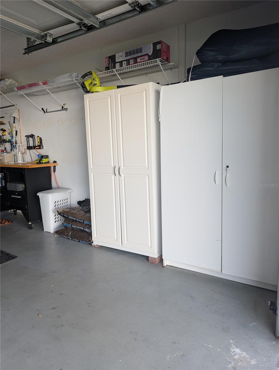 Extra storage cabinets (EZ Max Hurricane Mesh Screens stored above) & portable workbench.