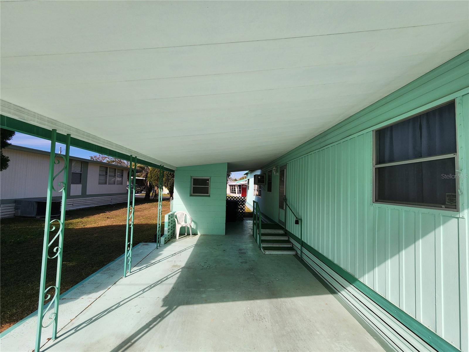 Carport, cement block utility room & main entry.