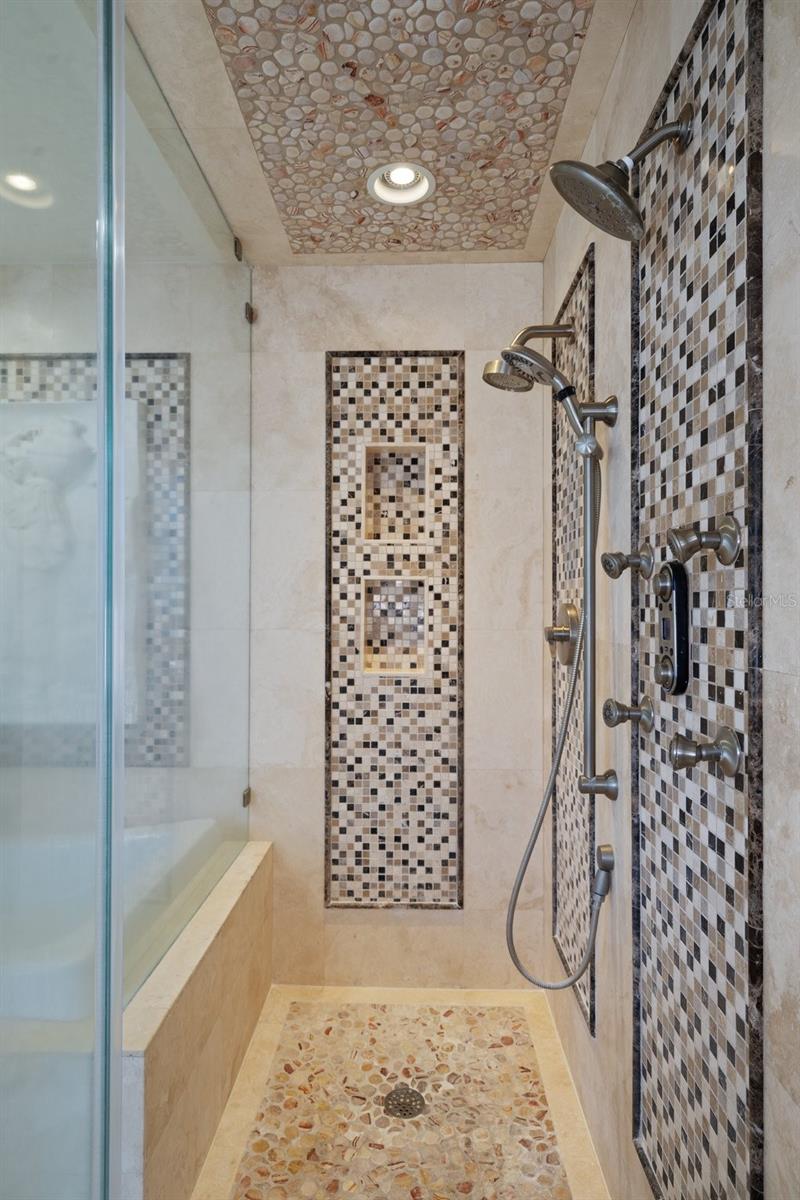 The shower has sleek, custom-tile work.