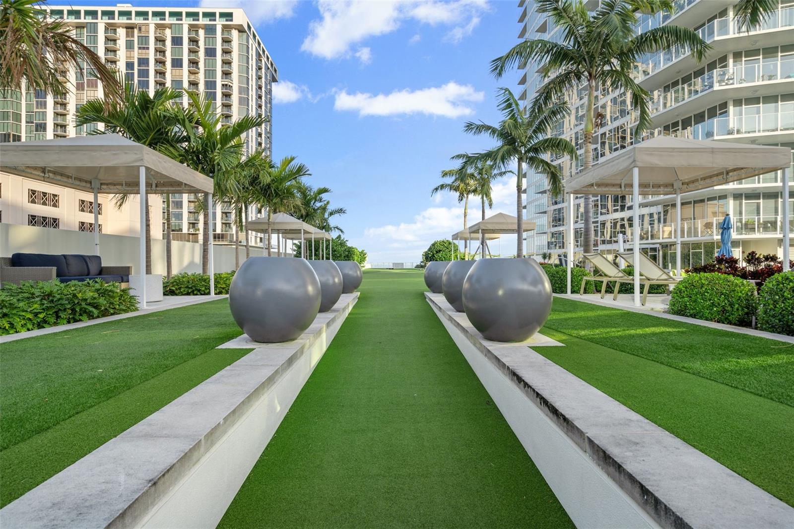 Lush landscaping on the pool deck includes gas grills.