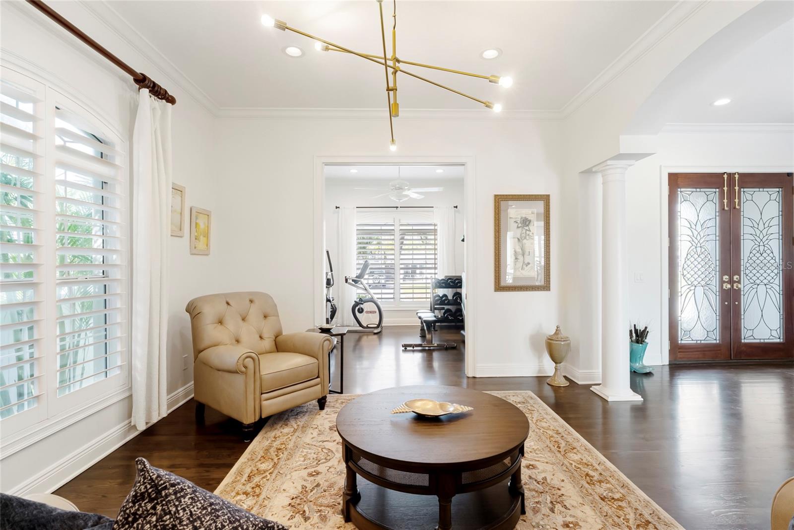 Living room with glass doors leading to the private office (currently being used as home gym)