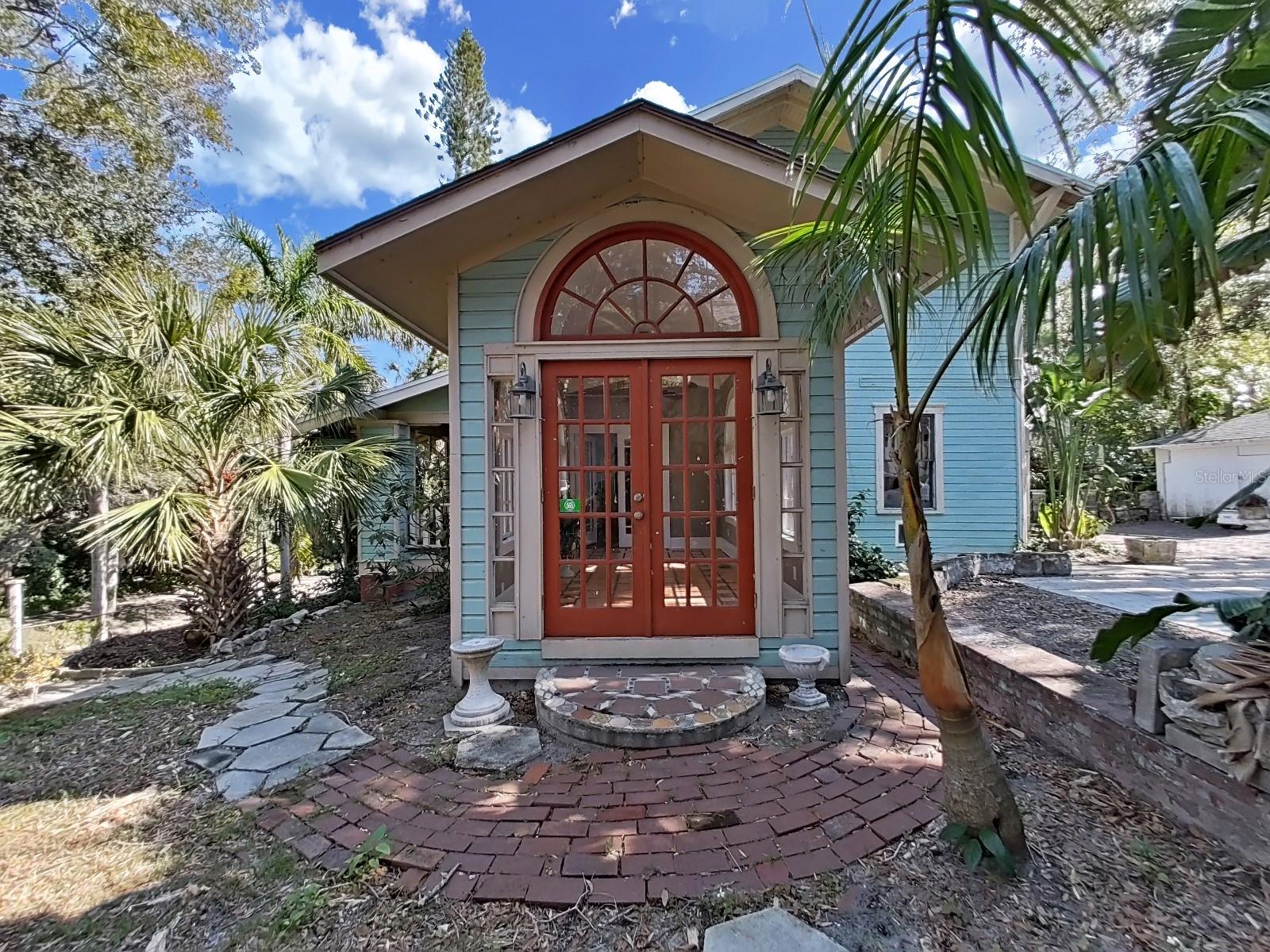 Sun room added with French doors, arched windows.