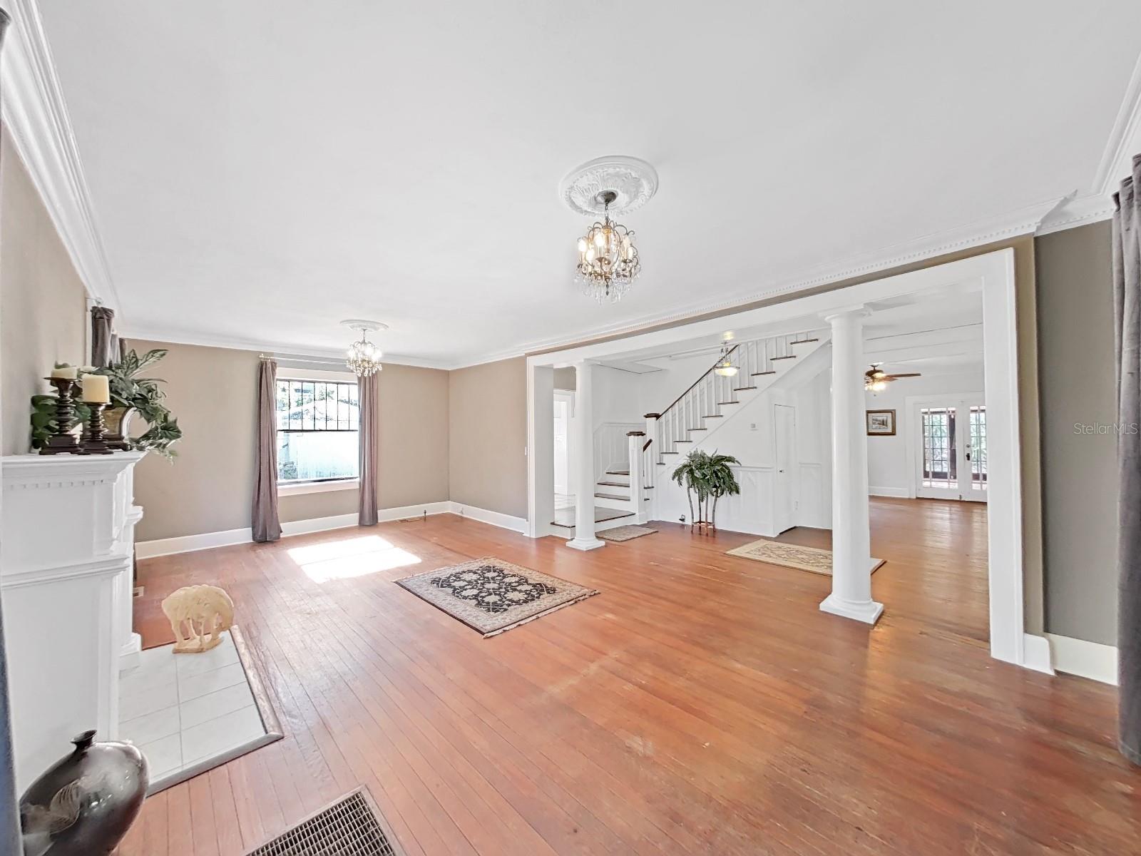 Full view of living room looking into large foyer with sweeping staircase and French doors in Dining room. For open entertaining areas.