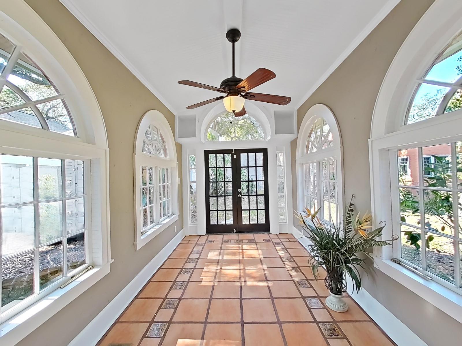 Sun Room with arched windows, French doors and inlaid tile.