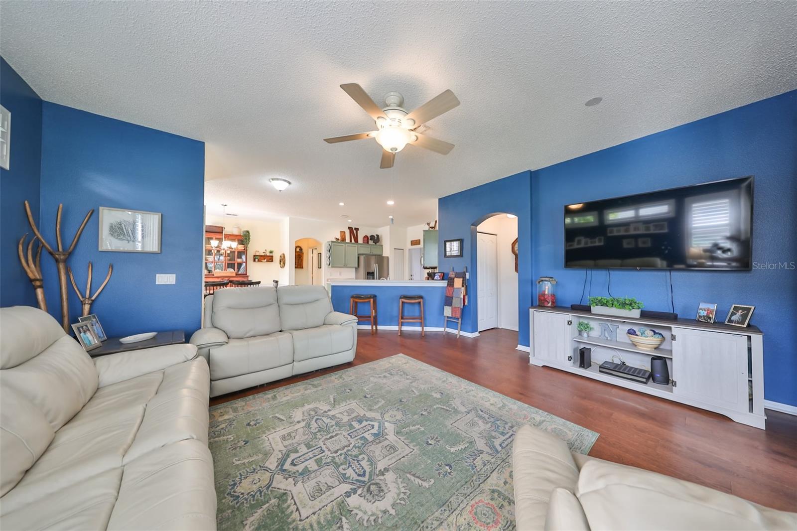 The living room offers a hospitable ambience to the environment with engineered hardwood flooring and plenty of lighting.