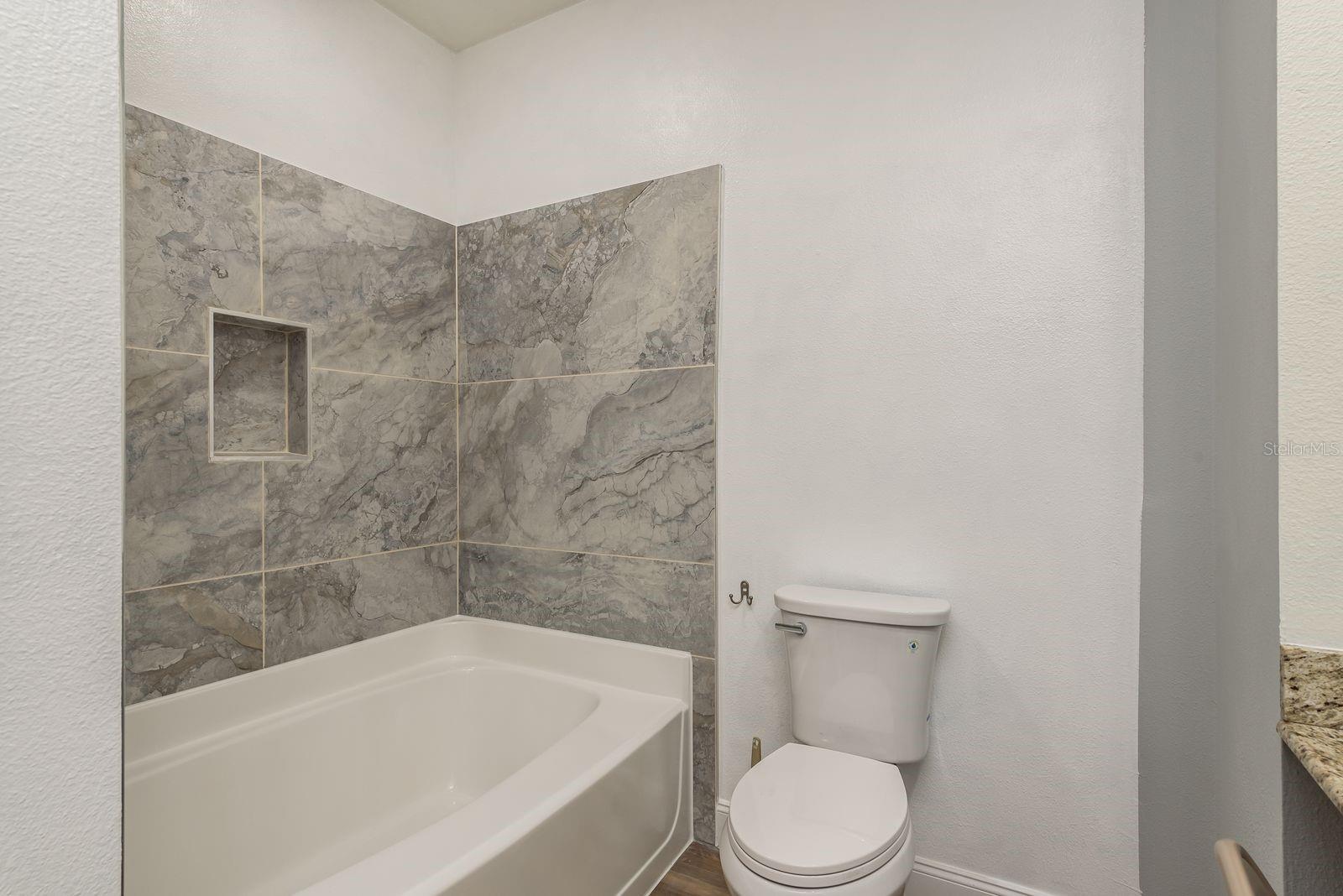 Brand new tile, shower head, and toilet in Primary Bath.