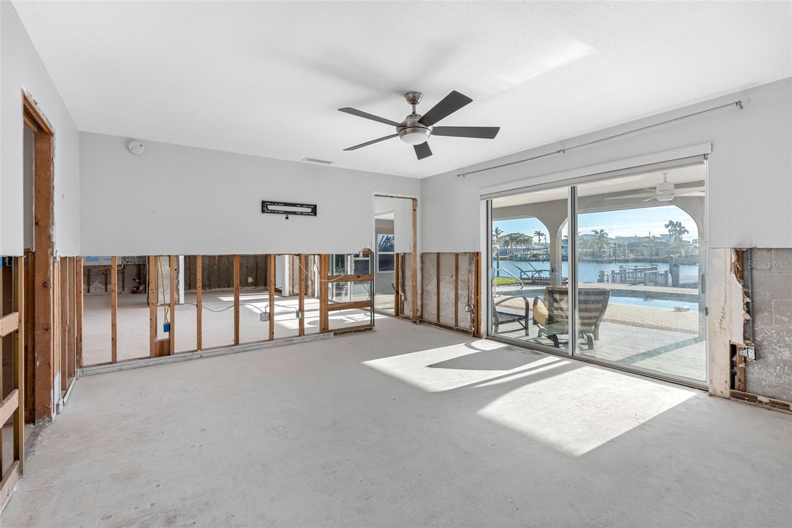 Large primary bedroom with pool and water views.