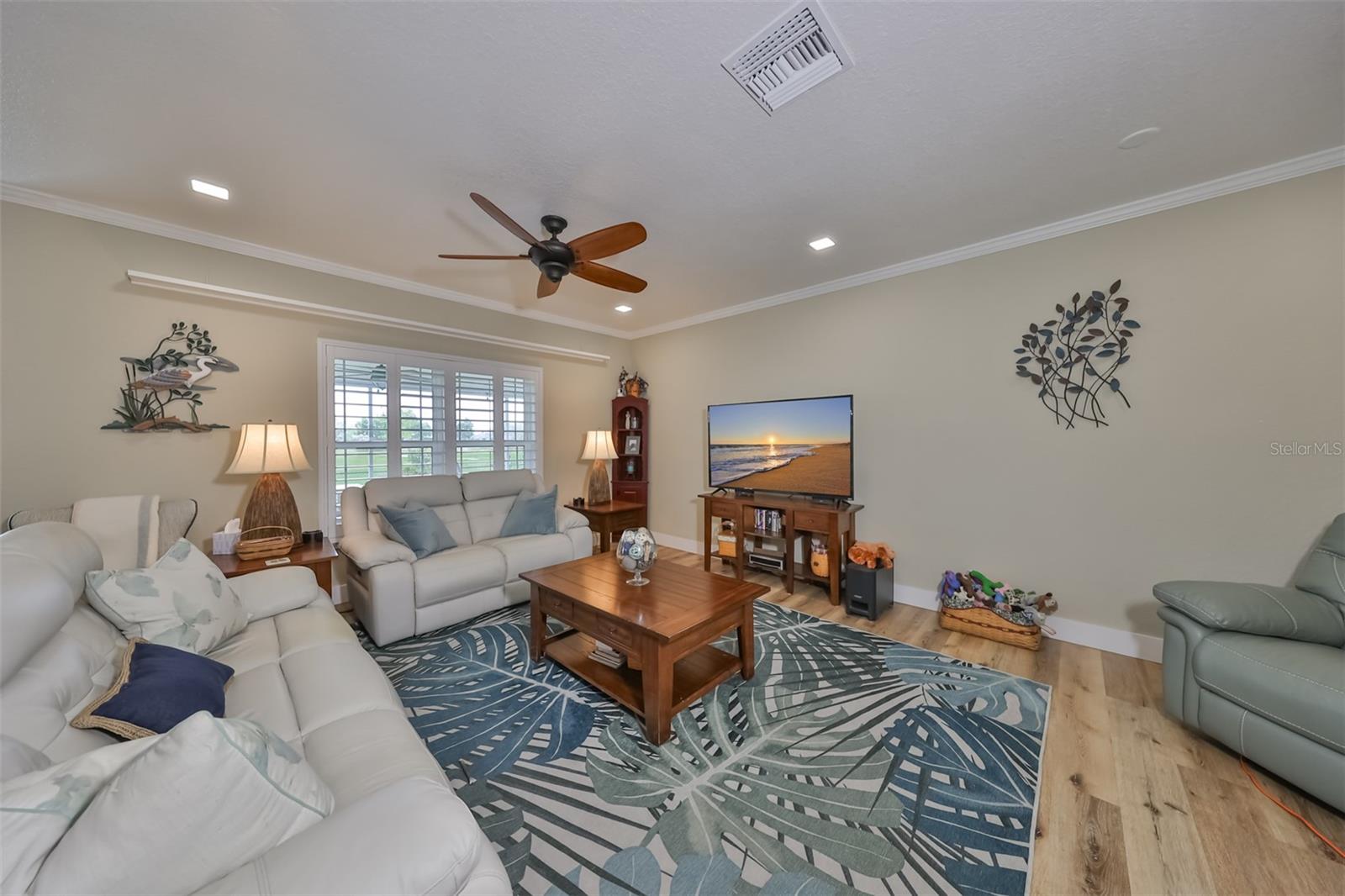 Modern recessed lighting, high art shelves and plantation shutters enhance the beauty of this room.