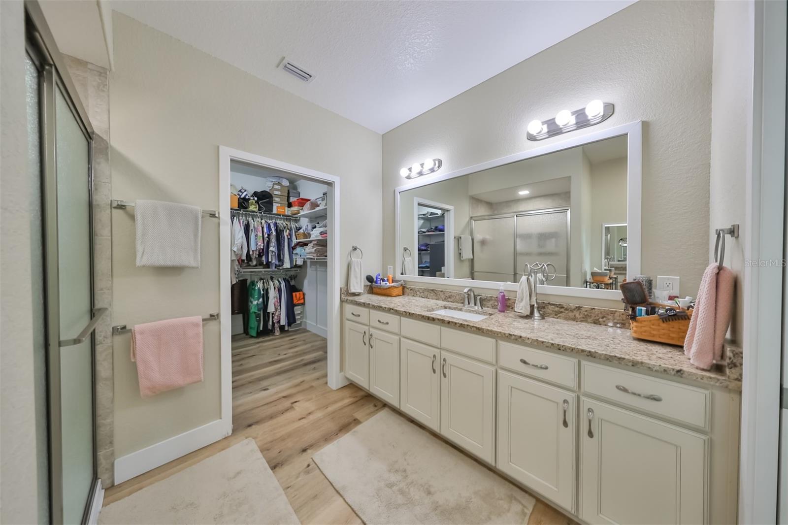 This en-suite bathroom has large walk-in shower, granite counters, modern fixtures and oversized ensuite walk-in closet room