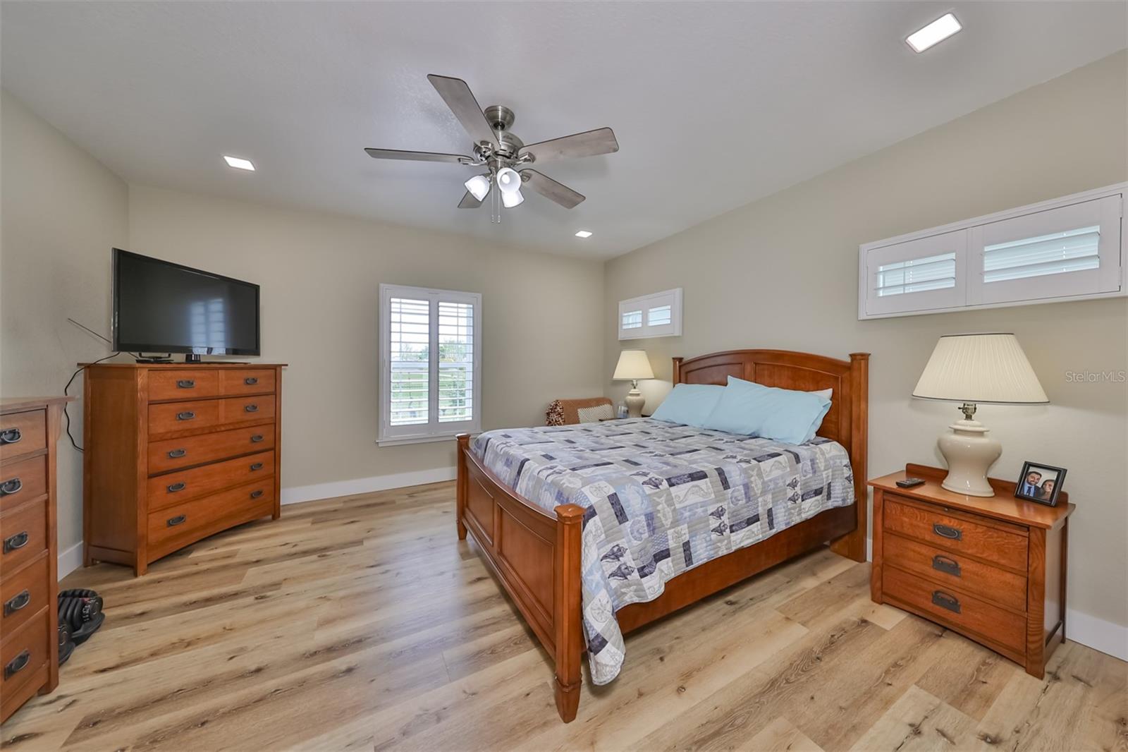 Bedroom 2 has many windows for extra lighting along with recessed lighting and high ceilings. Notice the matching flooring throughout.