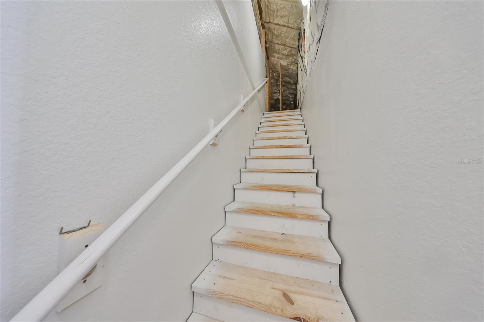 Indoor garage stairs leads up to indoor insulated attic, making safety first and comfort a priority.