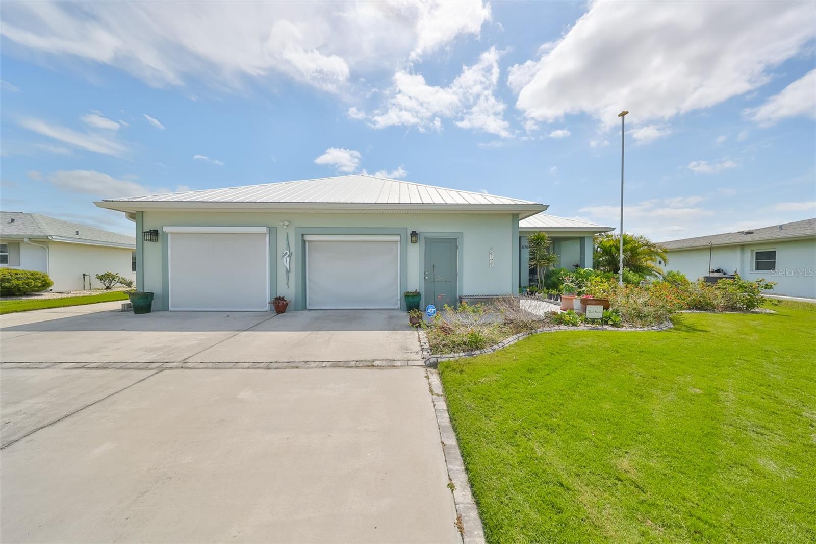 Modern front entrance with 2 car garage and additional side door entrance to garage, with privacy screens when you want to have the breeze blowing through the house.