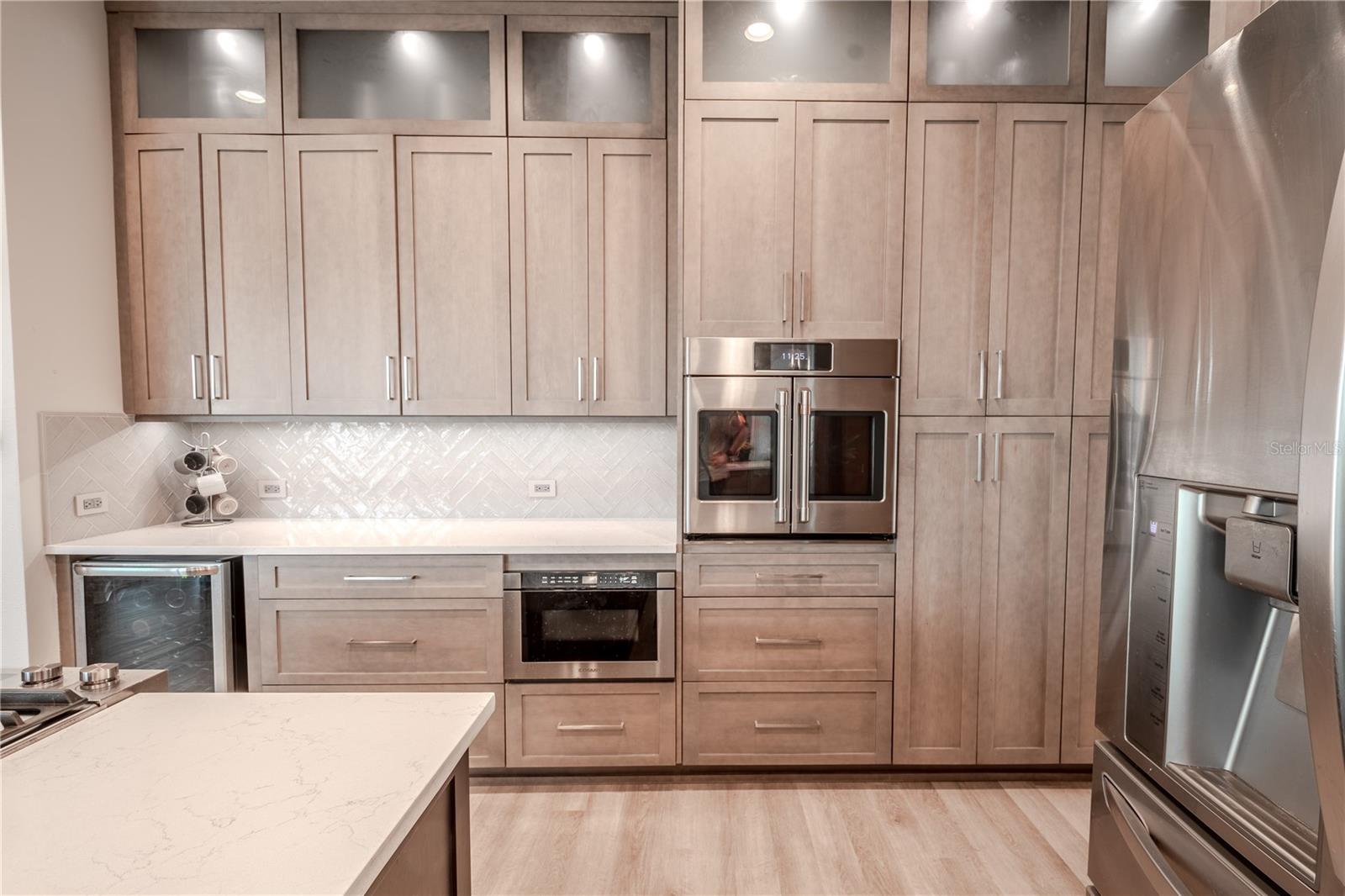 The kitchen features a built-in wall oven, microwave and wine refrigerator.