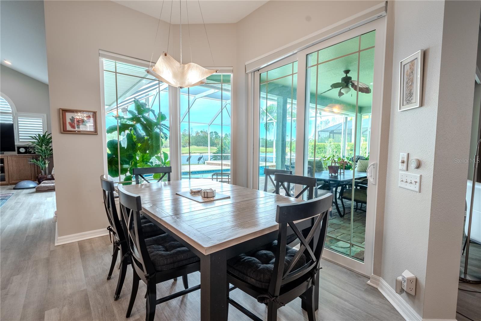 Large windows frame the breakfast nook with pool, pnd and golf course views.