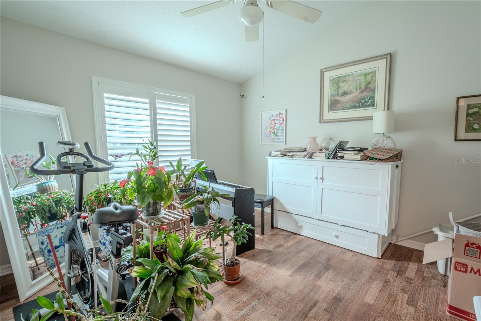 Bedroom 4 features wood flooring, a built-in closet, a ceiling fan and shutters.