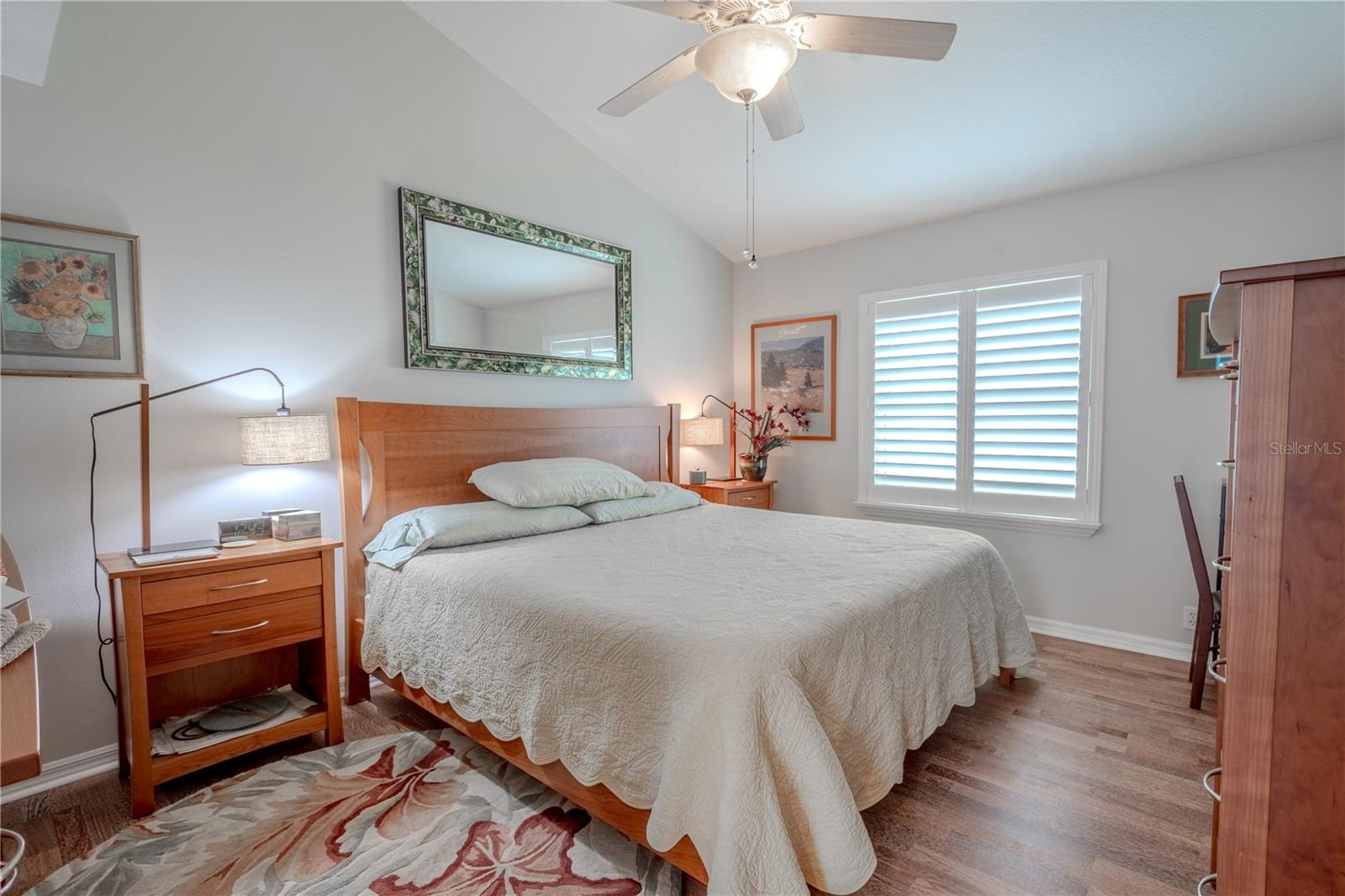 Bedroom 3 features wood flooring, a built-in closet, a ceiling fan and shutters.