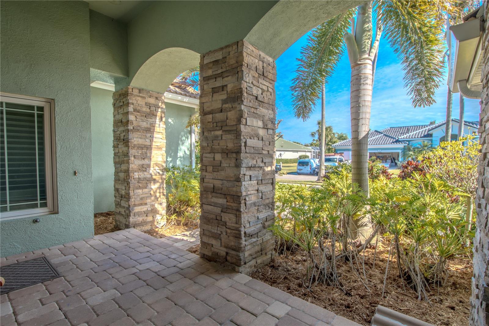 Arched  brick columns frame the covered front porch and entryway.