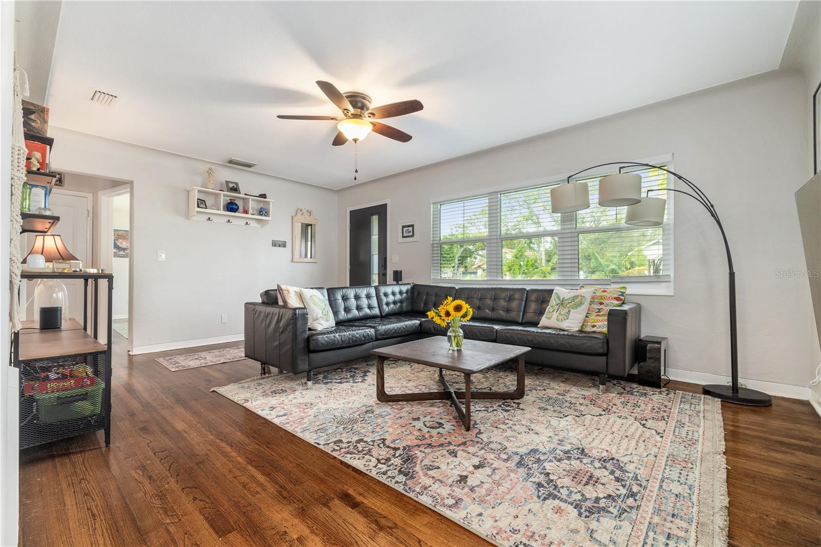 Light and bright main living room features original hardwood floors and elegant cove ceiling