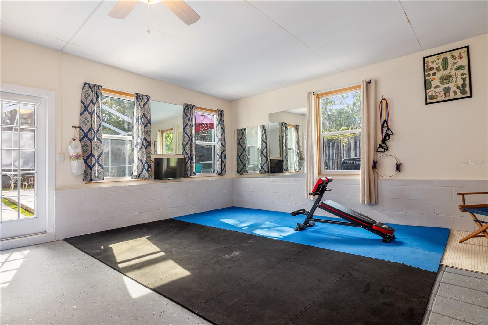 Light filled gym opens to the pool and patio.