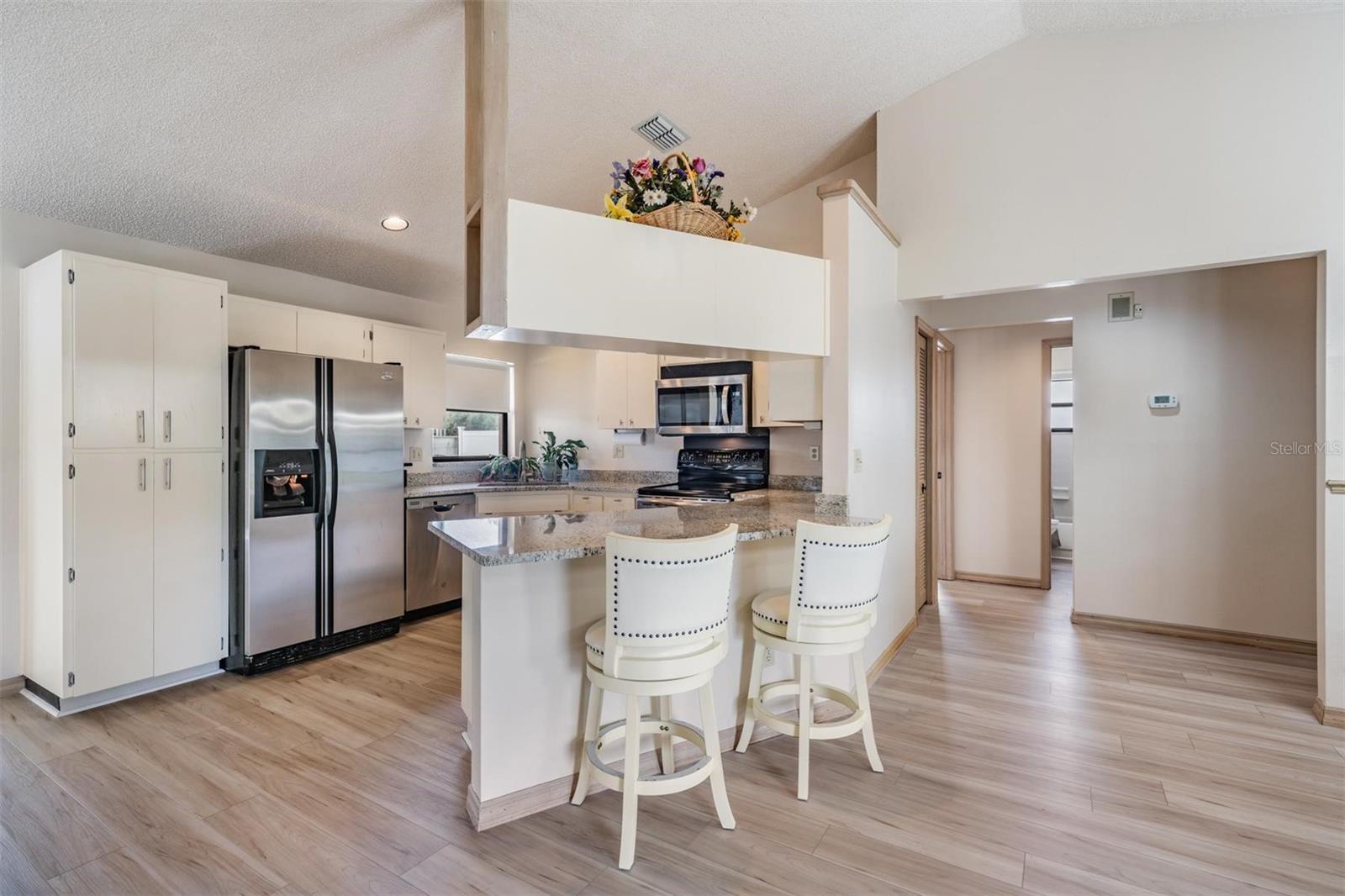 The kitchen features new granite countertops with breakfast bar, a reverse osmosis water system, new sink and fixture, and stainless-steel appliances