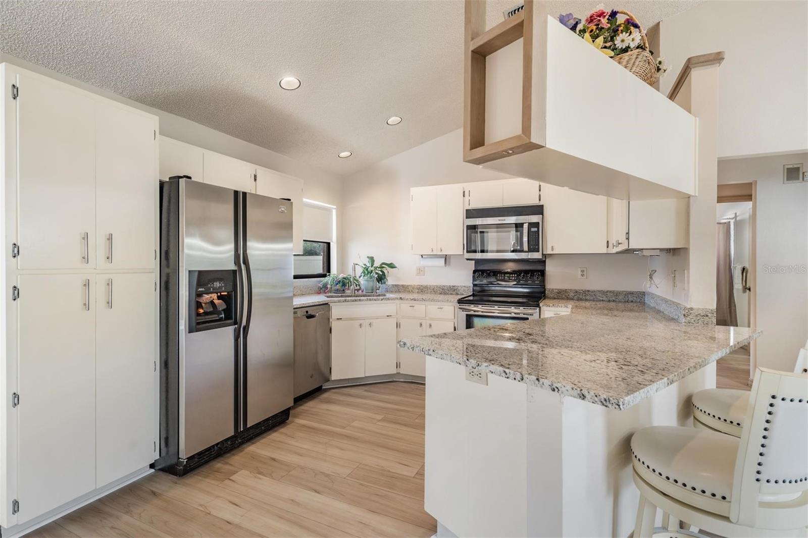 The kitchen features new granite countertops with breakfast bar, a reverse osmosis water system, new sink and fixture, and stainless-steel appliances