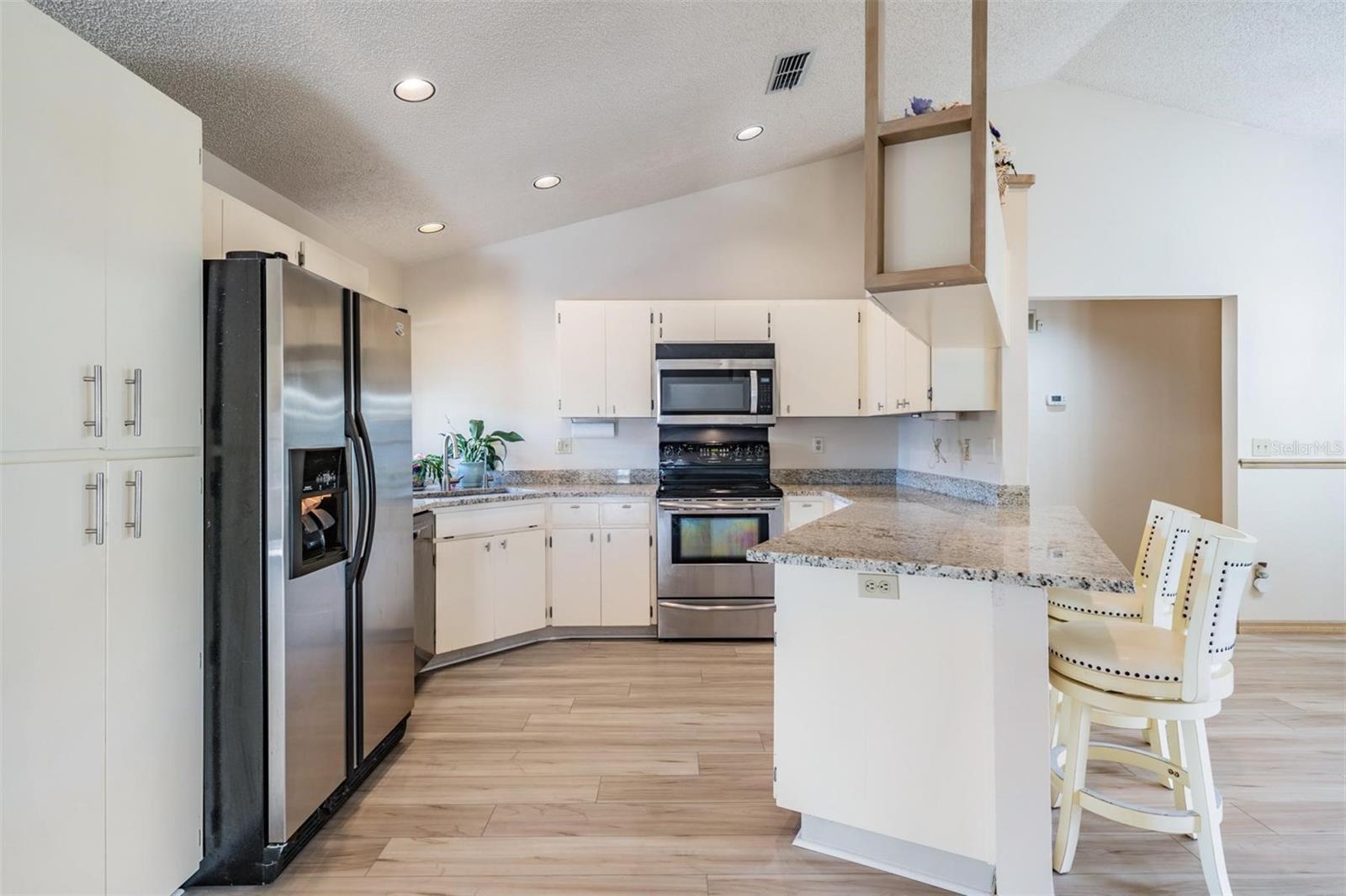 The kitchen features new granite countertops with breakfast bar, a reverse osmosis water system, new sink and fixture, and stainless-steel appliances