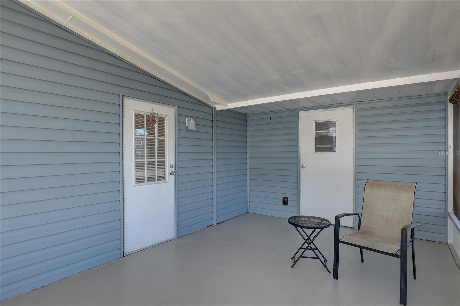 Covered screened-in porch with entry doors to kitchen hallway & laundry room