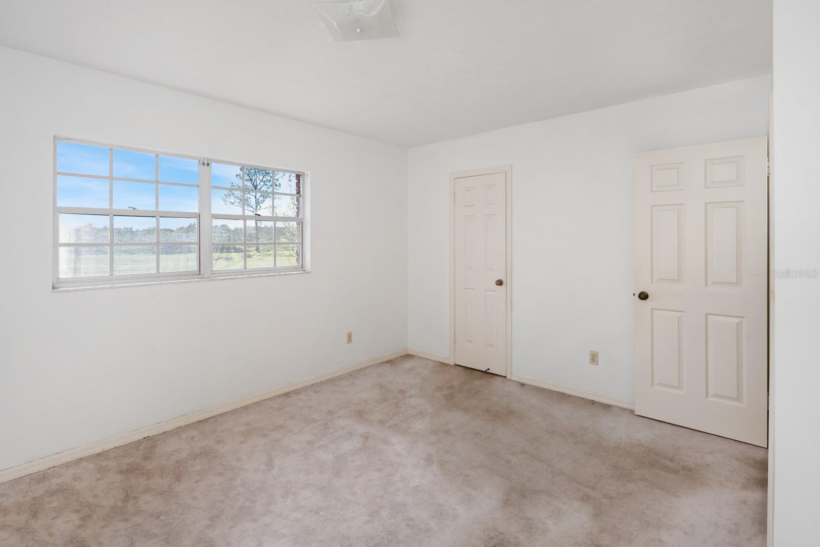 PRIMARY BEDROOM WITH BATHROOM DOOR