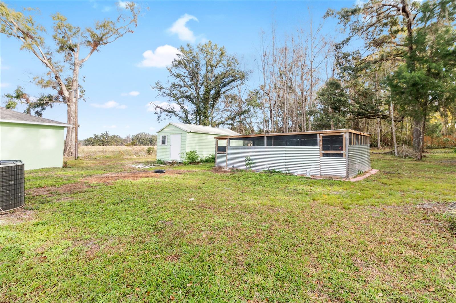 side/backyard view of the chicken coupe, shed and workshop/garage