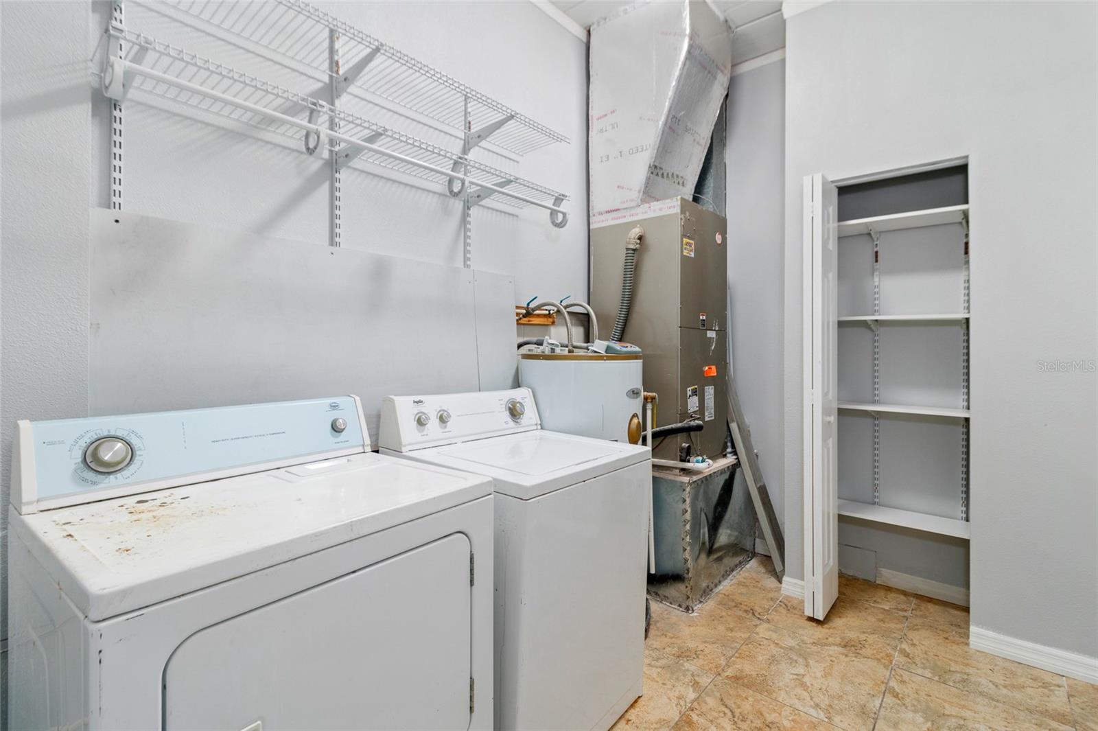 Spacious laundry room with shellves and pantry closet