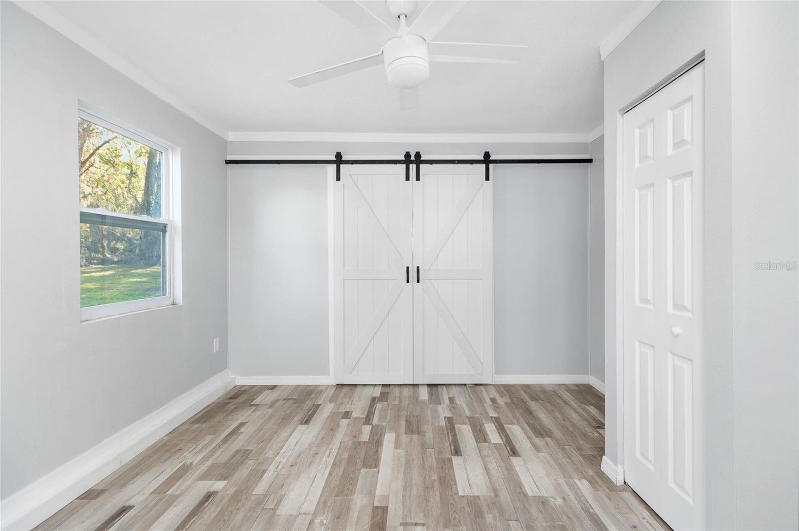 Primary suite facing the pretty barn doors which take you into the priary bathroom.