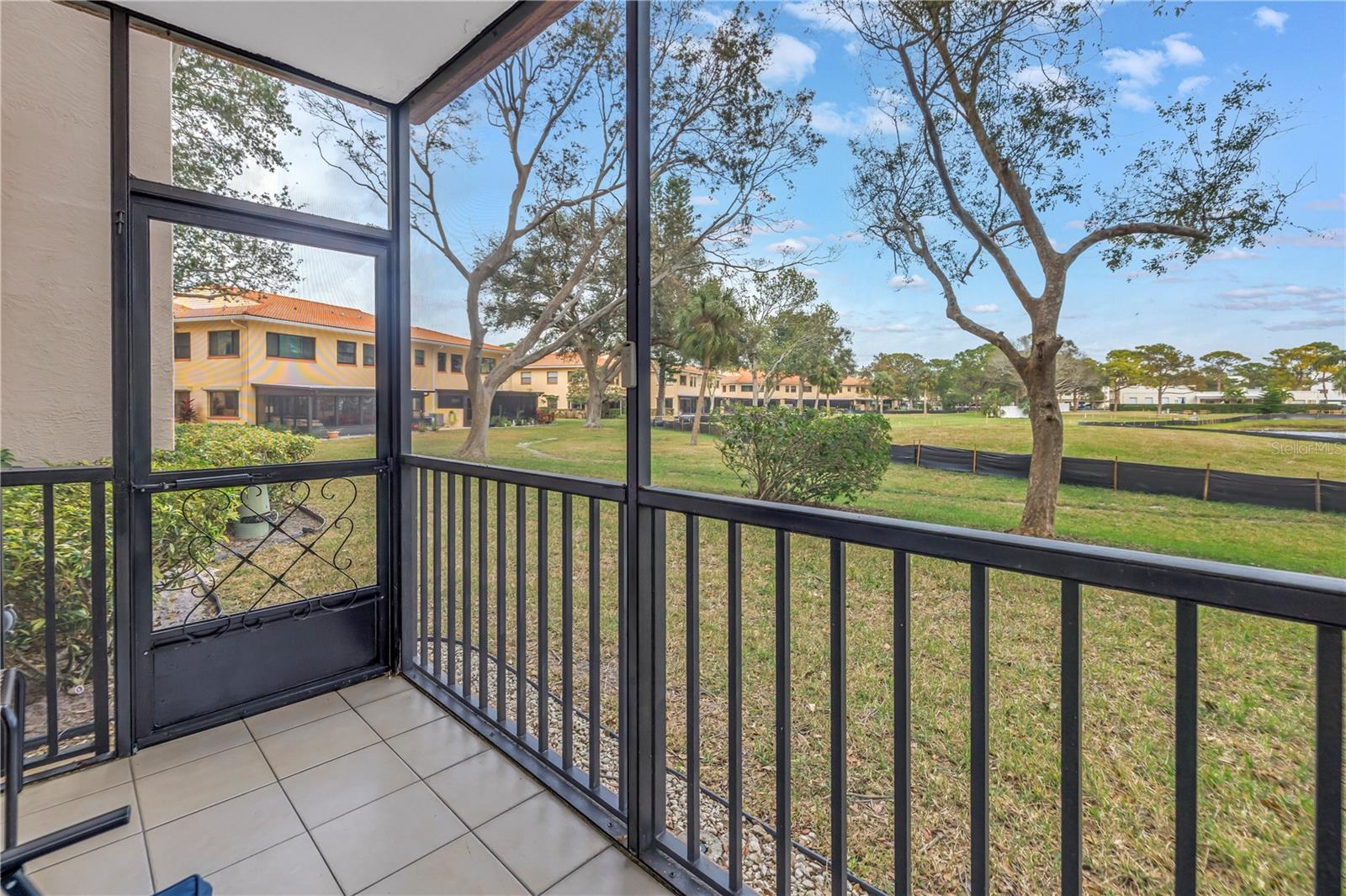 A covered, screened lanai that showcases peaceful pond views.