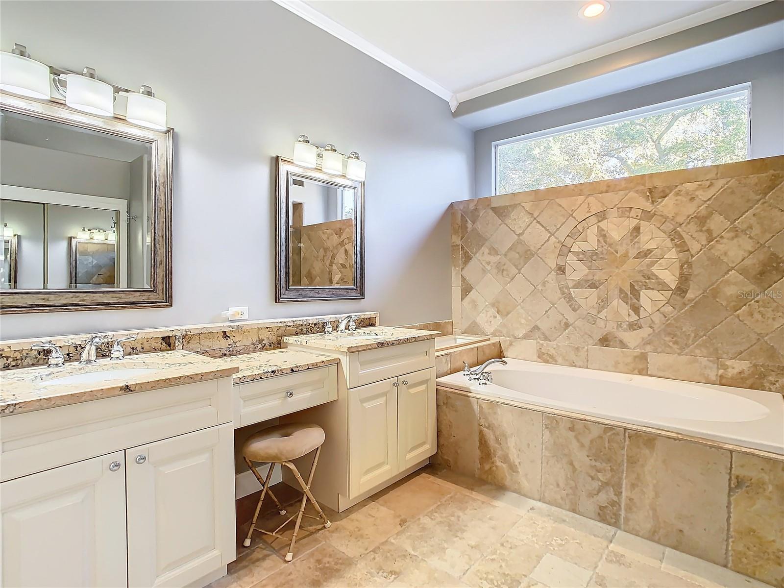 Enjoy the convenience of dual vanities and unwind in the jetted tub in this well-appointed master bathroom.