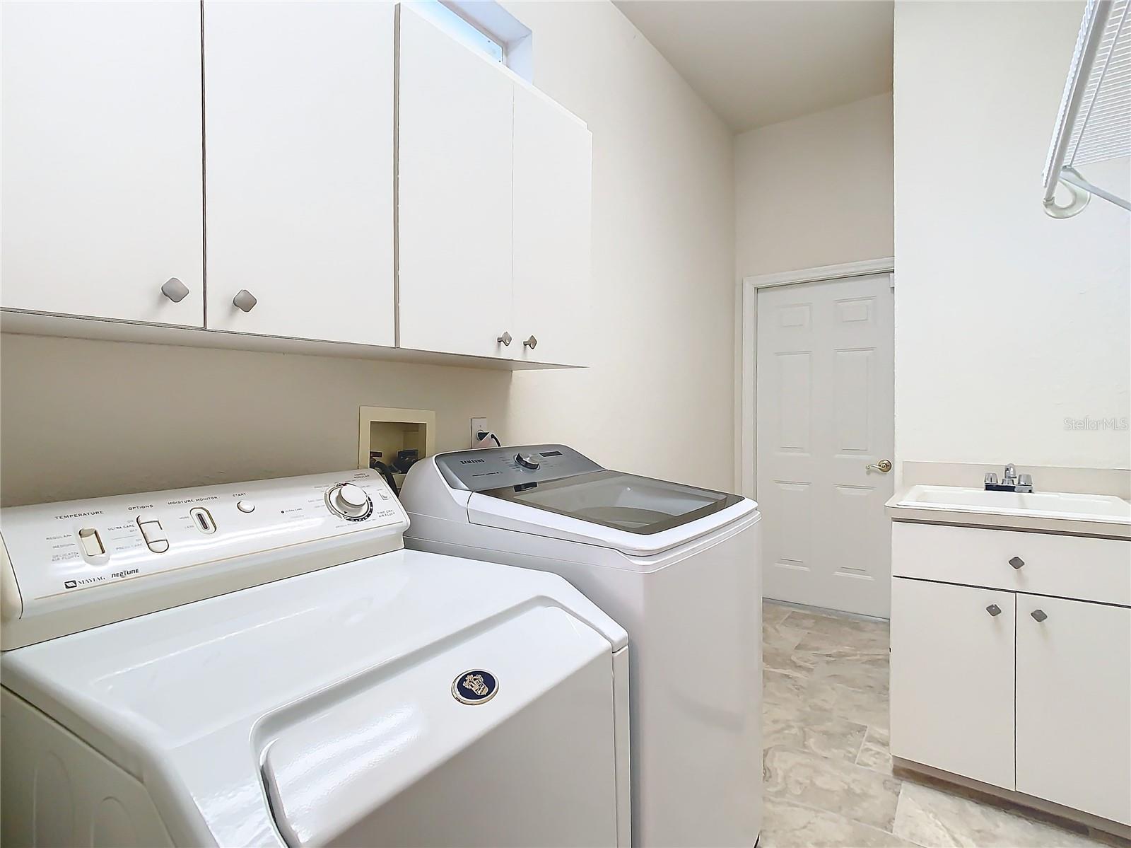 Stay organized in this well-equipped laundry room with plenty of cabinets and a dedicated sink for pre-soaking or hand-washing