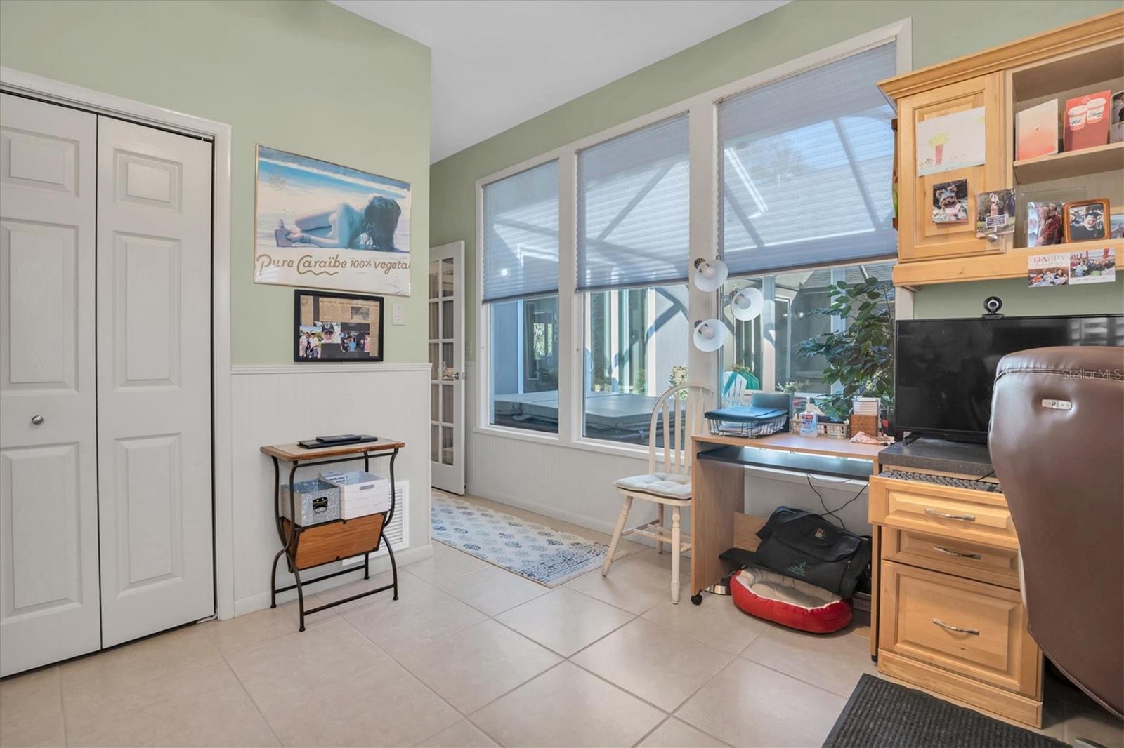 Bedroom 2 with built in desk and view to atrium