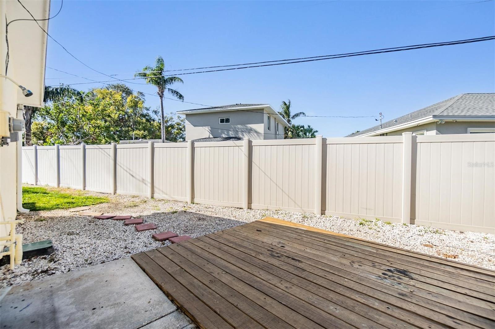 Side yard and entrance with new vinyl fencing.