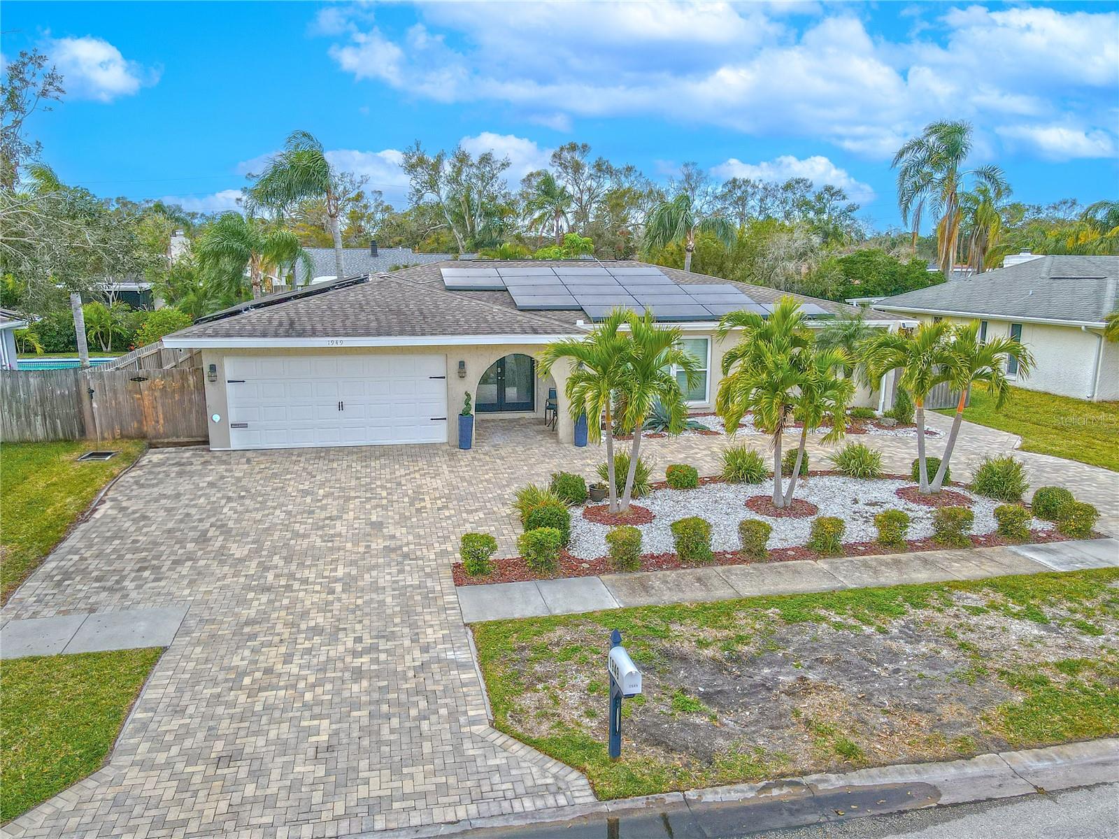 4-bedroom, 2-bath, 2-car garage, pool home with outdoor kitchen, screened-in lanai, and private fenced-in backyard.  Paved circular driveway accented by tropical landscaping.