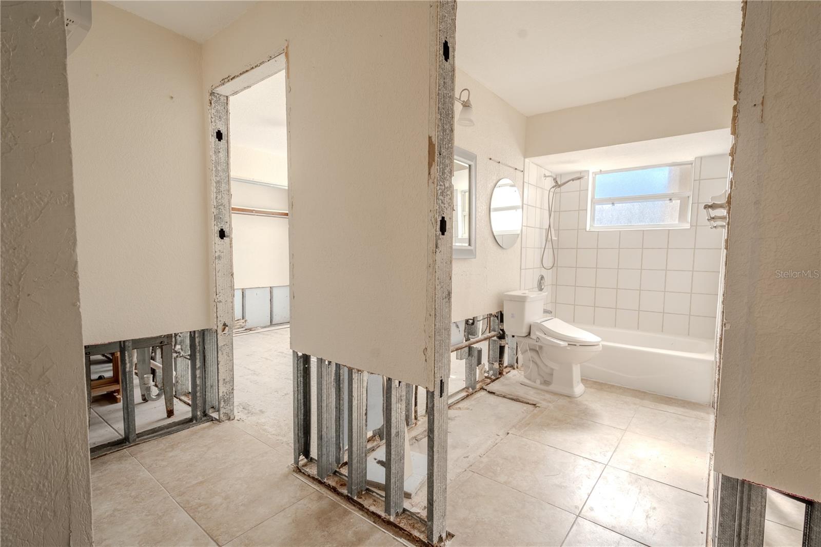 The 2nd bathroom has a tiled floor and a tub with shower.