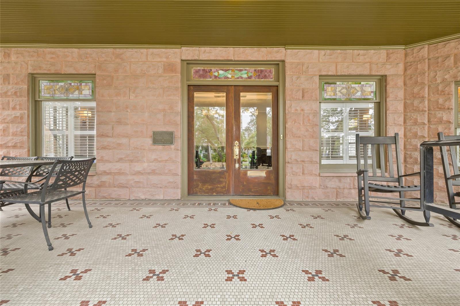 Gorgeous double-glassed front doors with antique stained glass transom.