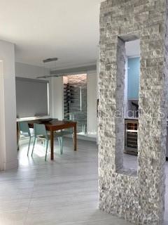 View into dining room featuring stone accent divider wall