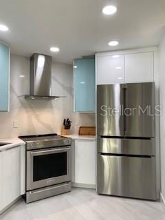 Kitchen view of fridge, range & hood