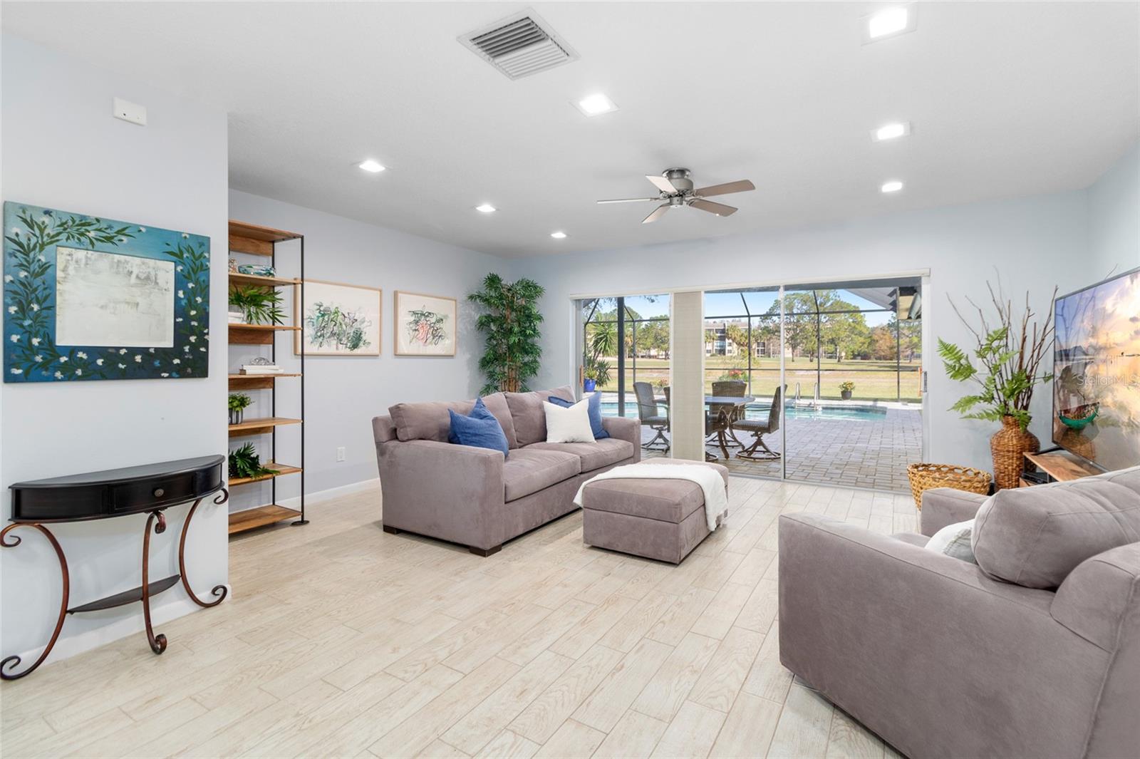 Living Room with wood like Ceramic tile flooring-triple slider to the patio