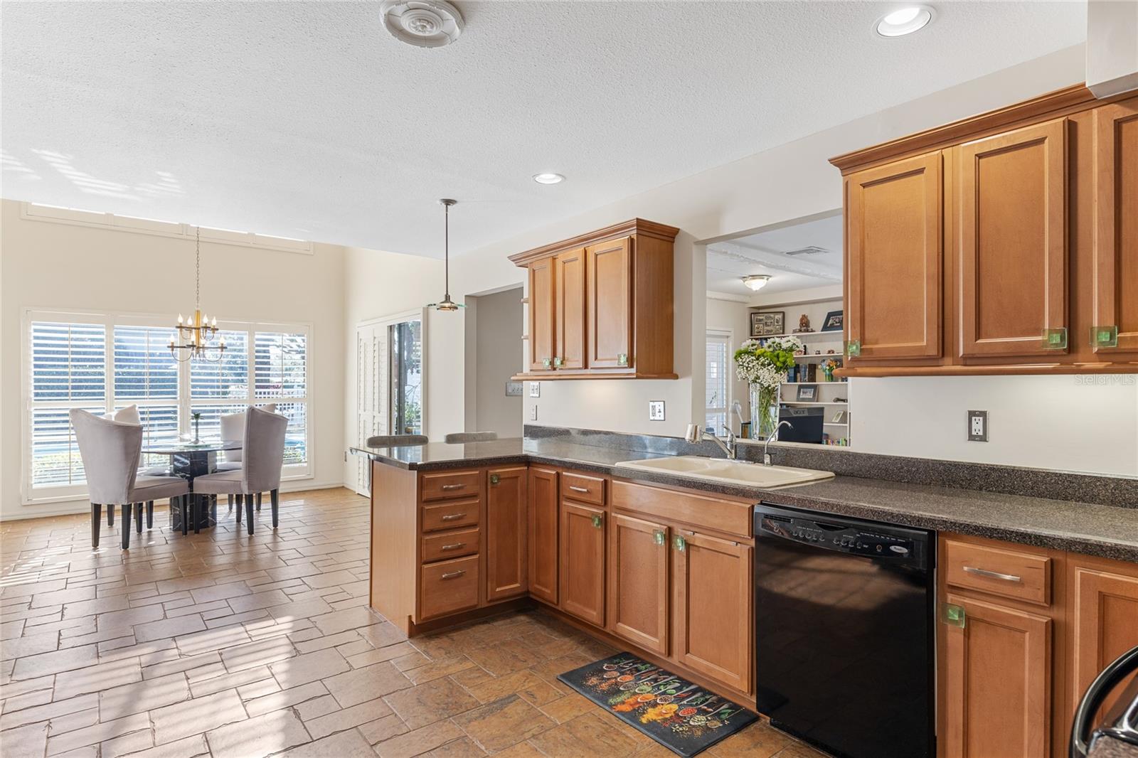 An alternate view of the kitchen reveals the cozy dinette area, along with a convenient pass-through opening to the living room, perfect for easy interaction and serving.