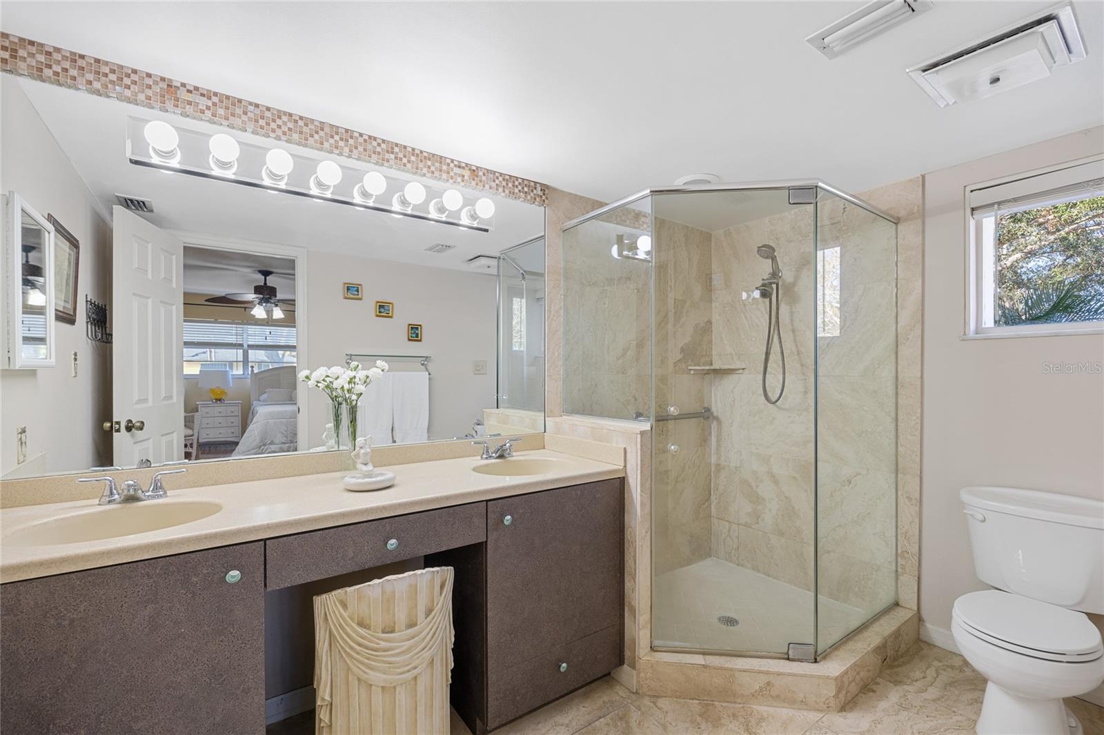 The ensuite bathroom for the ground floor bedroom is large and has a double sink vanity and all glass shower surround